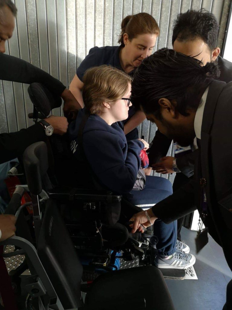 Special Assistance lifting disabled passenger to aisle chair